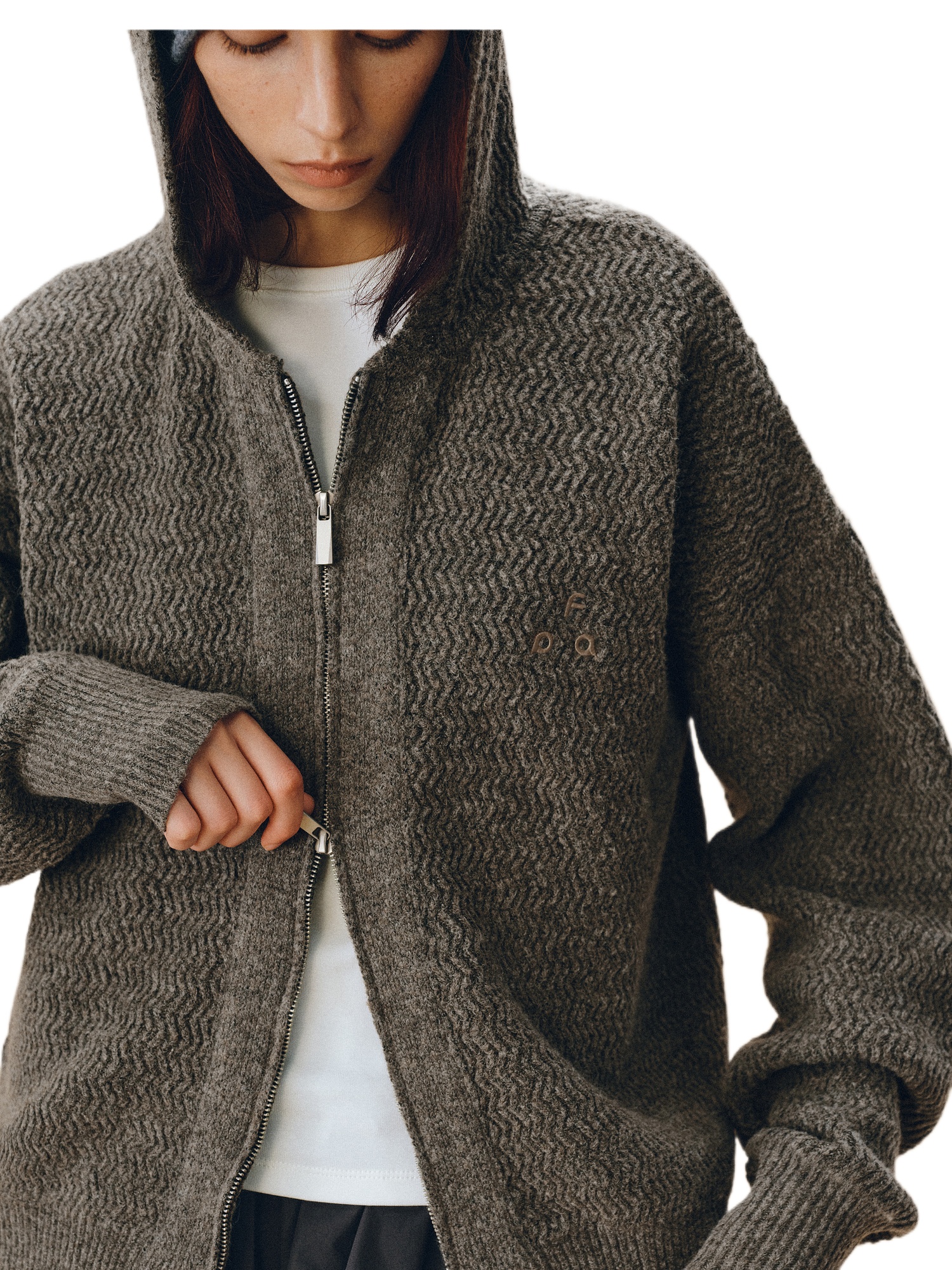 A person zips up an EastLyst Color-Block Hooded Cardigan over a white shirt, showcasing an easy athleisure style. Only the lower half of their face is visible.