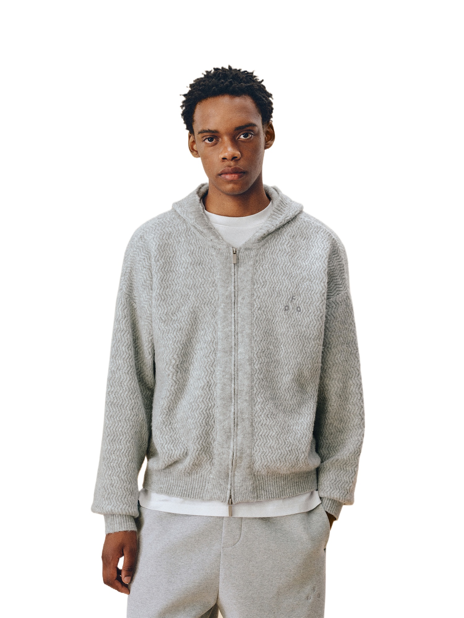 A person faces forward in an EastLyst Color-Block Hooded Cardigan over a white shirt and matching gray pants, showcasing a relaxed athleisure look against a plain white backdrop.