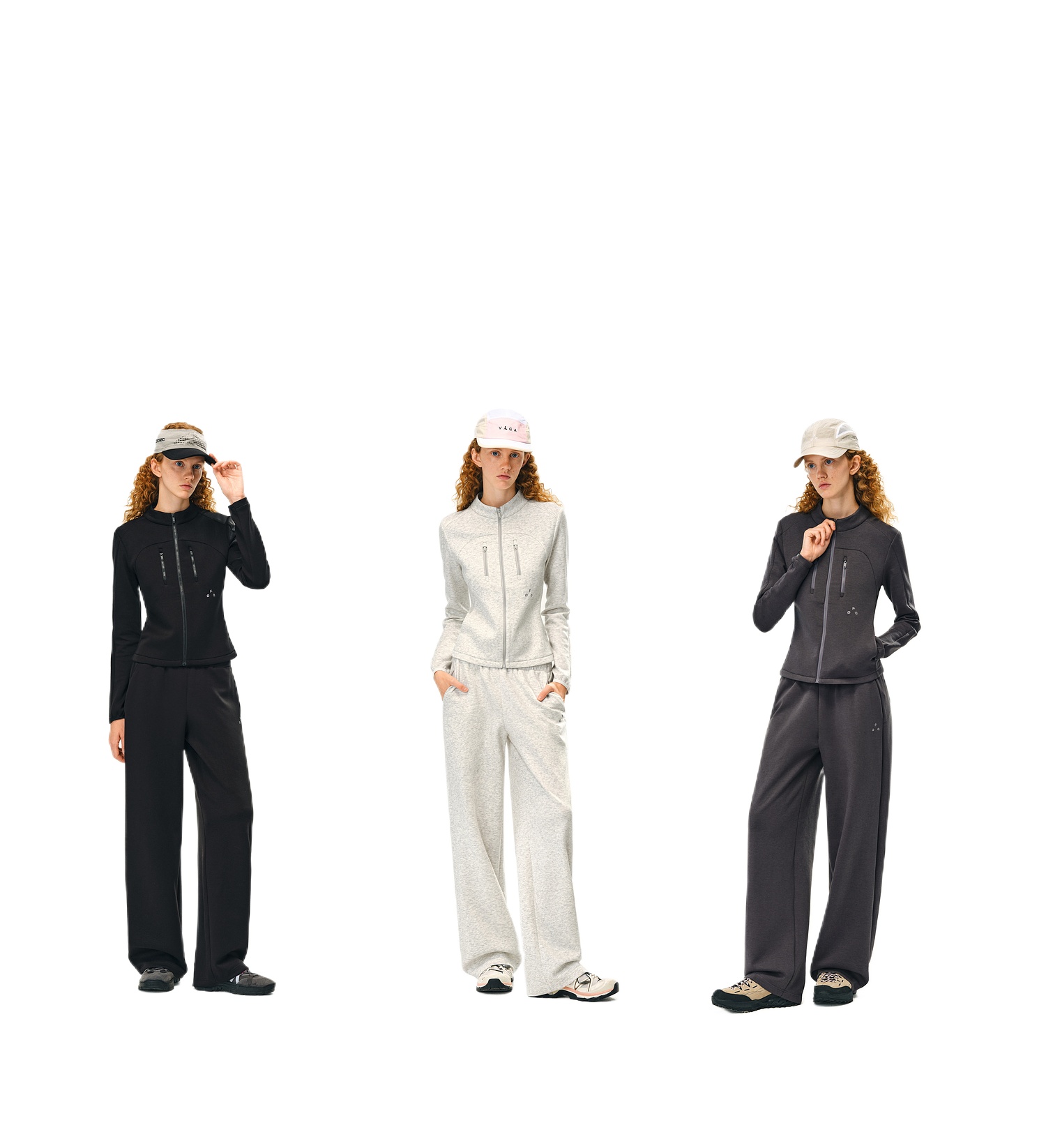 Three women wear EastLyst Double-Layer Air-Knit Wide Leg Pants sets in black, light gray, and dark gray, each featuring a zip-up jacket. Their outfits look silky. They all sport visors and sneakers, standing against a white background.